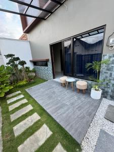 a garden with a patio with two chairs and a table at Omah Tentrem Magelang in Magelang