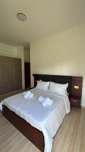 a large white bed with two towels on it at Pearl Escape in Entebbe +9 photos