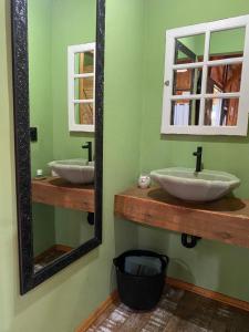 a bathroom with two sinks and a large mirror at Chalé Alpino Apiúna in Apiúna