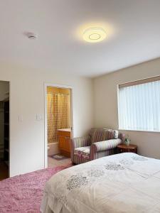a bedroom with a bed and a couch and a window at Cozy Home in Vancouver in Vancouver