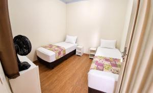 a small room with two beds and a door at Pousada Serra Dourada Mossâmedes in Mossâmedes +21 photos