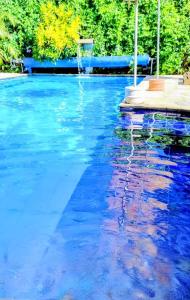 a pool of blue water with a basketball hoop at Recanto das Termas, Chalés in Termas do Ibirá