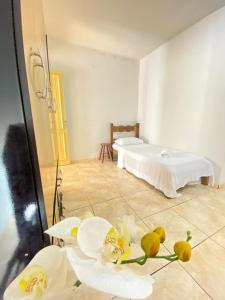 a room with two beds and flowers on the floor at Apto com garagem em Diamantina in Diamantina