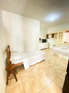 a room with two beds and a chair in it at Apto com garagem em Diamantina in Diamantina