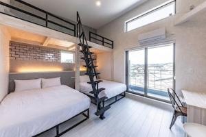 a bedroom with two bunk beds and a balcony at UG HOSTEL Takayama in Takayama