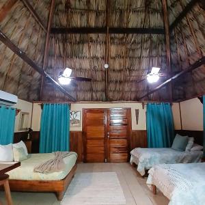 a bedroom with two beds and a thatched roof at Hotel Del Rio in San Pedro +114 photos
