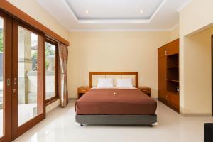 a bedroom with a bed and a large window at Kubu Petitenget Suite in Seminyak