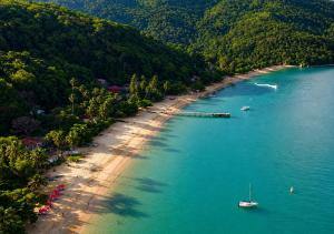 an aerial view of a beach with a boat in the water at Suítes Sol e Mar - Pé na Areia- Ilha Grande in Angra dos Reis