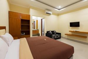 a bedroom with a bed and a flat screen tv at Kubu Petitenget Suite in Seminyak