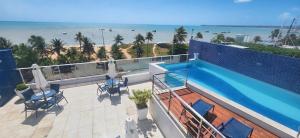 a balcony with a swimming pool and a view of the beach at Prédio Solar do Atlântico, apt 204 - Apartamento lateral em Tambaú in João Pessoa