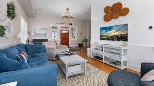 a living room with a blue couch and a tv at Summer Winds Sanctuary in Cape May