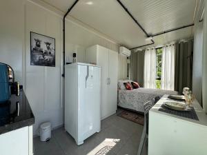 a kitchen with a refrigerator and a bed in a room at Charmoso e bem localizado! in Tijucas