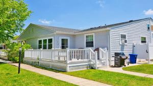 a house with a white porch and a fence at Illinois Avenue Hideaway in Cape May