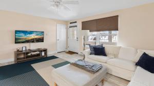 a living room with a white couch and a tv at Illinois Avenue Hideaway in Cape May