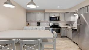 a kitchen with white cabinets and a table with chairs at Illinois Avenue Hideaway in Cape May +22 photos