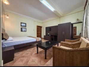 a bedroom with a bed and a table and chairs at Apsara Guest House, Peaceful Area in Central Shillong in Shillong +22 photos