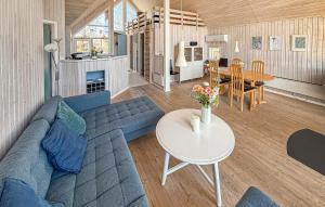 a living room with a blue couch and a table at Holiday Home Asperup 55 in Asperup