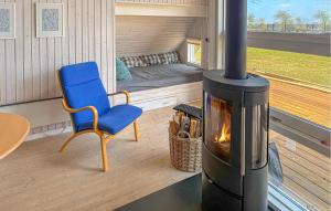a living room with a fireplace and a blue chair at Holiday Home Asperup 55 in Asperup