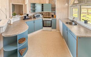 a kitchen with blue cabinets and a sink at Holiday Home Asperup 55 in Asperup +5 photos