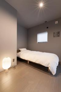 a bedroom with a large bed with a light on the ceiling at YOHAKU inuyama in Inuyama