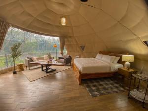 a bedroom in a dome tent with a bed and a couch at Tropical Escape Domes in Guápiles