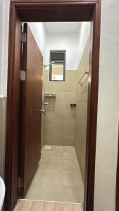 a bathroom with a shower with a glass door at Pearl Escape in Entebbe +8 photos