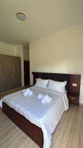 a large white bed with two towels on it at Pearl Escape in Entebbe