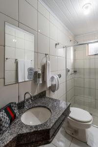 a bathroom with a sink and a toilet at Romas Hotel in Umuarama +37 photos