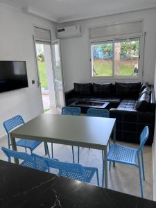 a living room with a table and chairs and a couch at Apparemment marina smir in Marina Smir