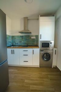 a kitchen with white cabinets and a washing machine at Ap Turísticos Marea - Frente al Mar in Mojácar +19 photos