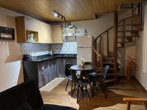 a kitchen with a table and chairs and a refrigerator at Chalé Recanto da Grota in Passa Vinte
