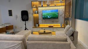 a living room with two couches and a flat screen tv at Ohana's Beach House in Punta Negra