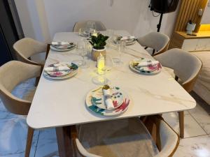 a white table with plates and glasses on it at Ohana's Beach House in Punta Negra