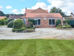 a house with a gravel driveway in front of it at Brompton Lodge in Ganton +23 photos