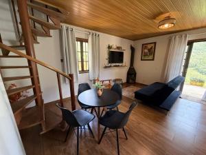 a living room with a table and chairs at Chalé Recanto da Grota in Passa Vinte