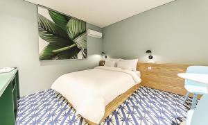 a small bedroom with a bed and a table at Hotel Yeogiuhtte Chungjangro in Gwangju