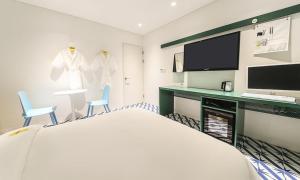 a hotel room with a bed and a desk and a tv at Hotel Yeogiuhtte Chungjangro in Gwangju