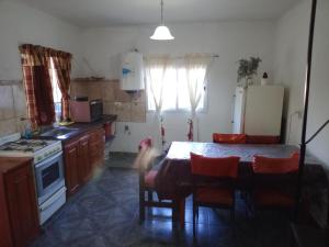 a kitchen with a table and chairs and a kitchen with a refrigerator at Duplex Hermosinda Hospedaje in Chilecito