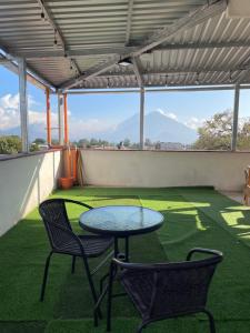 a patio with a table and two chairs on the grass at Casa Borde de lago2 in Panajachel