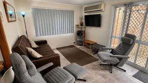 a living room with a couch and two chairs at At Busso Cabin 56 in Broadwater