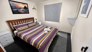 a bedroom with a bed with a stuffed animal on it at At Busso Cabin 56 in Broadwater +26 photos