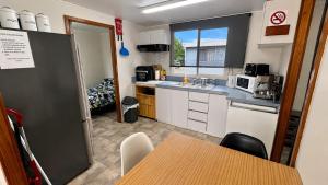 a kitchen with white cabinets and a table in it at At Busso Cabin 56 in Broadwater