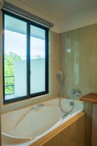a bath tub in a bathroom with a window at Arena Blanca in Rasdhoo