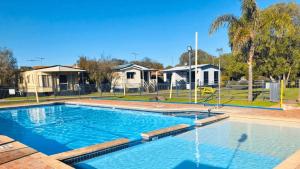 a large swimming pool in a yard with houses at At Busso Cabin 56 in Broadwater