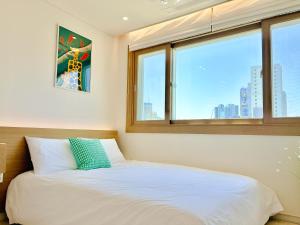 a bed in a room with a window at Fine On Stay Jeonpo in Busan