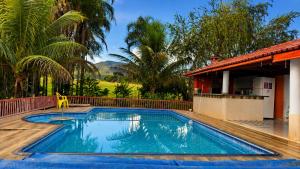 a swimming pool in front of a house at Pousada Serra Dourada Mossâmedes in Mossâmedes