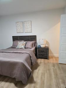 a bedroom with a bed and a dresser with a night stand at Serene luxury apartment in Moncton
