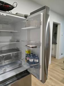 an empty refrigerator with bottles of water in it at Serene luxury apartment in Moncton +21 photos