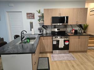 a kitchen with a sink and a stove top oven at Serene luxury apartment in Moncton