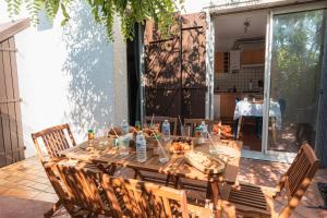 a wooden table with food on it on a patio at Le Cocon Méditerranéen - Plage à 5 min - Place de Parking - Barbecue - Terrasse in Le Barcarès